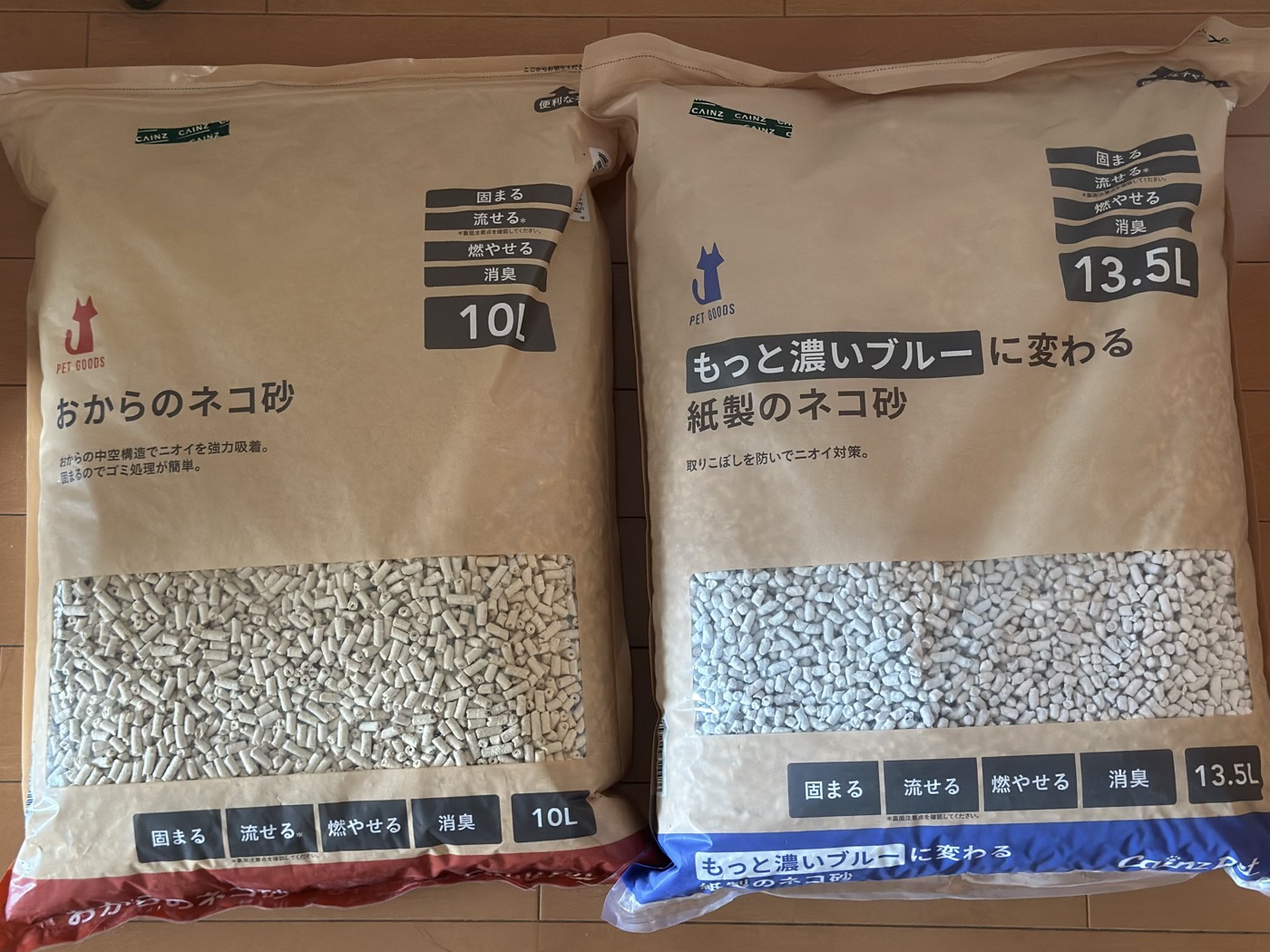 カインズのおからのネコ砂10Lと、もっと濃いブルーに変わる紙製のネコ砂13.5Lを床に並べた写真